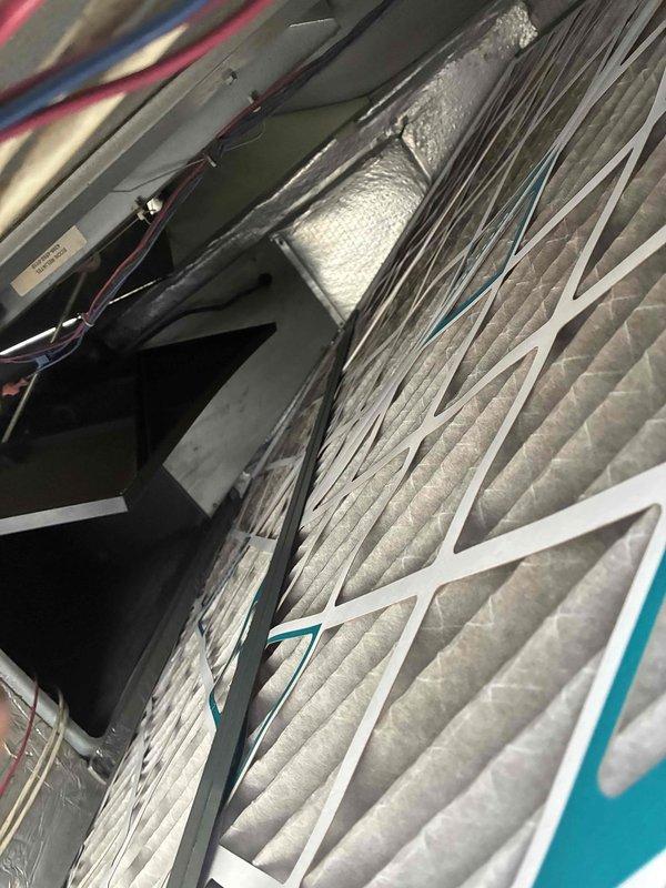 # HVAC Service Report

Responded to commercial service call regarding excessive humidity concerns. Performed comprehensive inspection of air conditioning system and air handling unit components. Examined air filtration system, finding two 20x25x12 MultiPleat filters installed in the air handler with visible dust accumulation. Inspected internal HVAC components including evaporator coil assembly, refrigerant lines, and electrical connections. Noted copper refrigerant lines showing normal oxidation patterns consistent with operational equipment. Verified proper installation of ductwork with foil-faced insulation and foam sealing materials. Documented current system condition through photographic evidence for service records. All electrical wiring connections and control circuits appear secure with proper labeling in place.