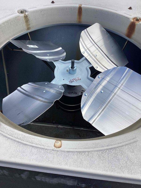 Replaced failed condenser fan motor and blade assembly on commercial HVAC unit. Removed existing motor with corroded mounting hardware, installed new Hartzell fan motor with three-blade assembly, and secured protective wire grille. Unit tested and operational upon completion.