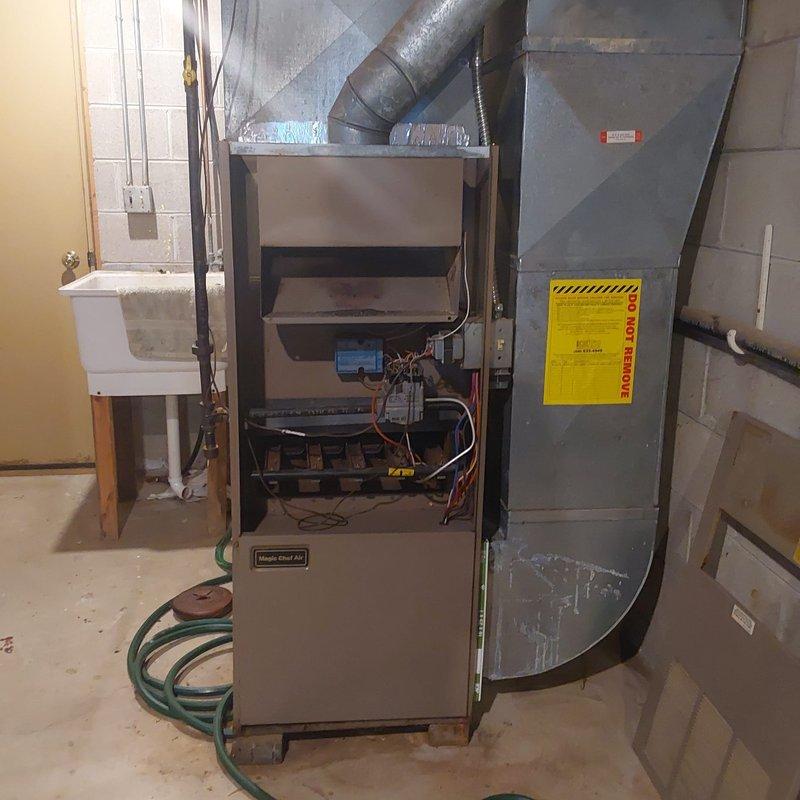 Completed comprehensive HVAC system evaluation for furnace and air conditioning retrofit installation. Assessed existing equipment configuration in basement mechanical room, including furnace unit with internal components, ductwork connections, and gray sheet metal air handler assembly. Evaluated outdoor condenser unit positioned on concrete pad with refrigerant line routing along exterior wall, confirming proper placement and clearances for optimal system performance.