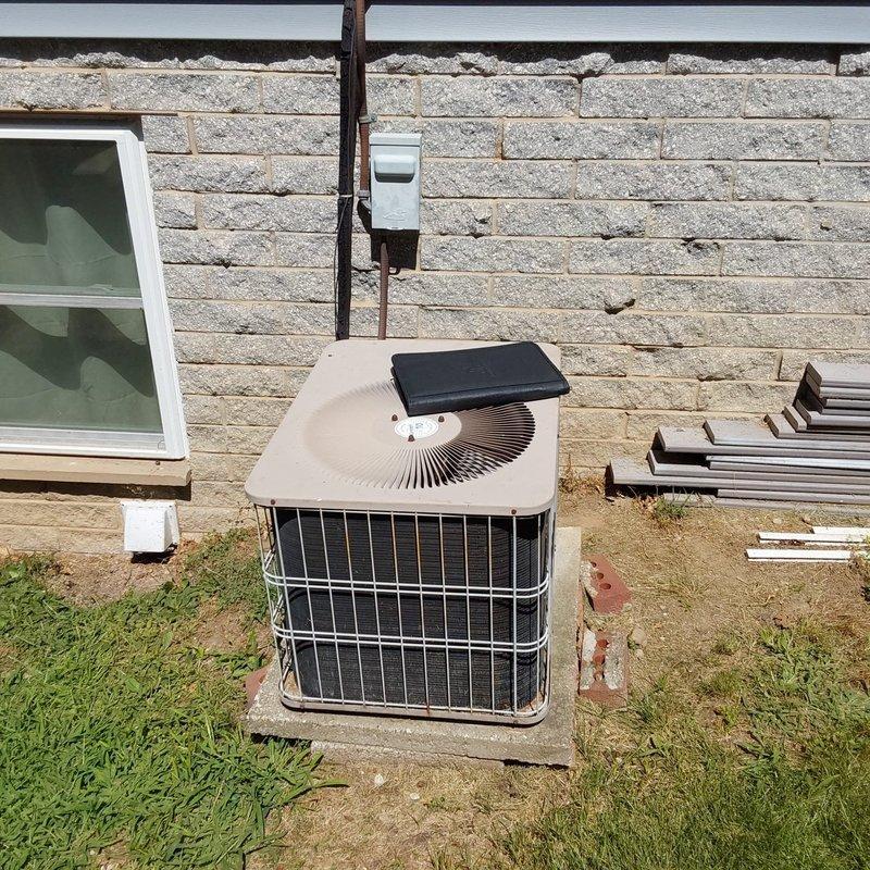 Conducted site evaluation for complete furnace and air conditioning system replacement at residential property. Assessed existing outdoor condensing unit positioned on concrete pad with electrical disconnect and conduit installation. Evaluated indoor furnace system located in basement mechanical room, including ductwork configuration with visible moisture accumulation and proximity to water heater. Documented current equipment conditions and discussed available equipment options including Lennox brand systems for replacement consideration.