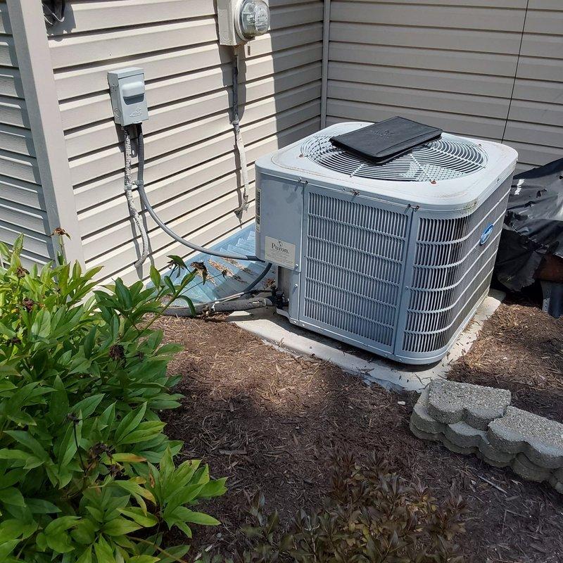 Completed full HVAC system retrofit in residential basement utility room, installing new Carrier furnace and outdoor condensing unit. Removed existing equipment and installed complete heating and cooling system with proper venting, electrical connections, condensate drainage via PVC piping, and refrigerant line set. Mounted exterior disconnect box, positioned condenser unit on concrete pad with proper clearances, and verified all connections for safe operation.
