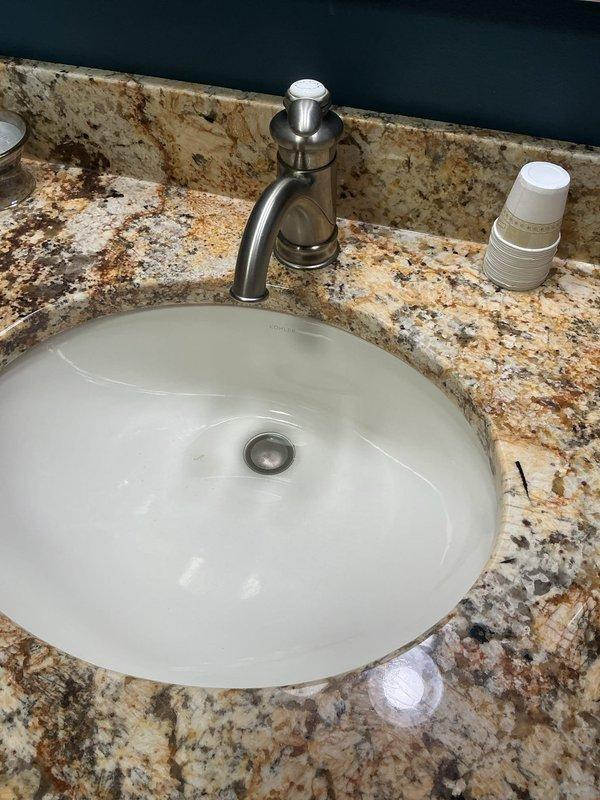 Responded to service call for two separate sink issues in residential property. First location: master bedroom bathroom sink experiencing repeated drainage problems. Removed and cleaned faucet aerator to restore proper water flow, which had become restricted due to mineral deposit buildup. Second location: upstairs office/suite bathroom sink with stuck pop-up drain stopper assembly. Disassembled and freed the stuck stopper mechanism, cleaned drain components, and reassured proper operation of both the stopper and drainage system. Both fixtures tested and confirmed operational upon completion.