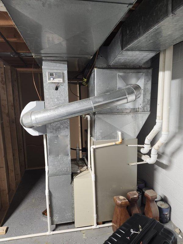 Completed full HVAC system retrofit in basement mechanical room, including new furnace and air conditioning equipment installation. Installed furnace unit with properly configured supply and return ductwork, mounted vertical plenum with integrated controls, and ran PVC condensate drain lines in accordance with manufacturer specifications. All ductwork secured to ceiling joists with appropriate fasteners, system tested and verified operational upon completion.