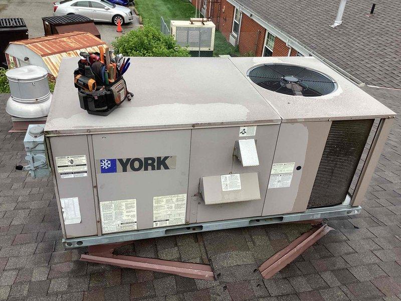 Responded to service call for insufficient cooling in small laundry area. Upon arrival, inspected Honeywell Home digital thermostat displaying 77°F with handwritten temperature control instructions on wall indicating setpoint of 66°F. Proceeded to rooftop and performed diagnostic inspection of York packaged RTU system. Conducted thorough evaluation of unit operation, checked refrigerant levels, inspected electrical connections, and verified proper airflow through ventilation louvers. System was found to be operating within normal parameters but required minor adjustments to optimize cooling performance for the confined laundry space. Verified proper thermostat communication with rooftop unit and ensured system cycled correctly. Unit tested and confirmed adequate cooling delivery upon completion of service.