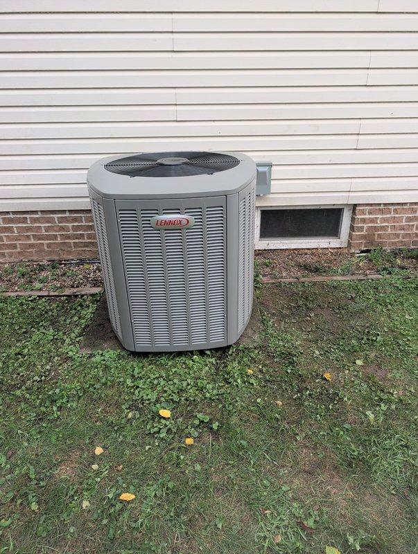 Completed AC retrofit installation featuring a new Lennox outdoor condensing unit and matching evaporator coil. Unit was positioned on existing pad against exterior foundation, with all refrigerant lines properly connected and insulated. System was pressure tested using digital manifold gauge, achieving 401.4 psig with leak test passing all parameters including allowable drop of 0.5% over 5-minute test duration and pressure drop remaining within acceptable limits at 0.4% change per minute. All electrical connections secured, condensate drainage verified, and unit commissioned for optimal performance.