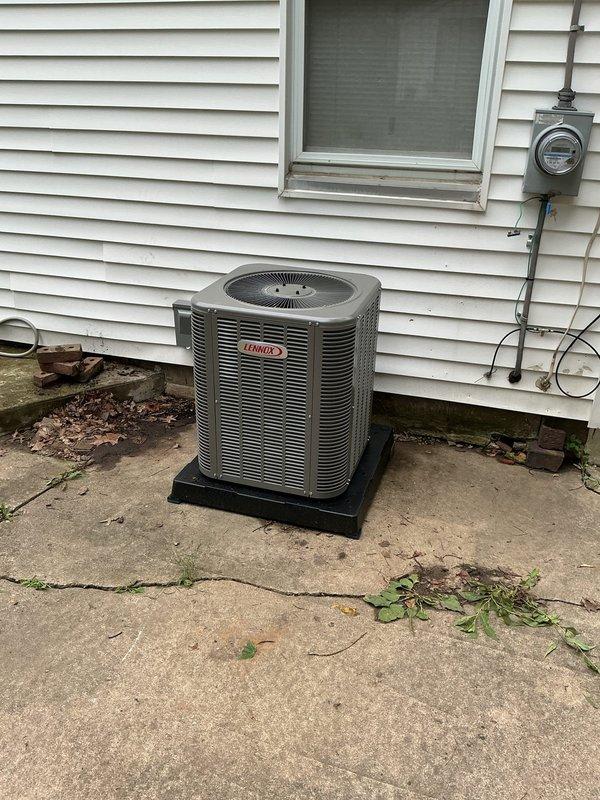 Completed full HVAC system retrofit including outdoor Lennox air conditioning condenser unit and indoor furnace with associated ductwork. The exterior condenser was professionally mounted on a stable pad against the building exterior with proper electrical connections routed from the existing meter, while the indoor furnace installation featured new metal ductwork, air handling components, and proper integration with the existing water heater and utility infrastructure in the basement mechanical room.