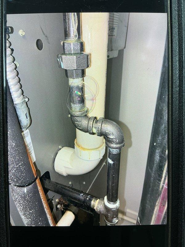 Responded to callback for unresolved gas leak on furnace supply line. Upon arrival, inspected gas piping assembly and fittings at furnace connection point. Located active leak at threaded union connection between galvanized steel pipe and brass valve assembly. Applied leak detection solution to verify exact leak location at threaded joint. Shut off gas supply via red-handled ball valve, depressurized line, and disassembled union fitting. Cleaned threads, applied appropriate pipe thread sealant, and reassembled connection to manufacturer specifications. Pressurized system and performed leak check with soap solution—no leaks detected. Restored gas supply and verified proper furnace operation.