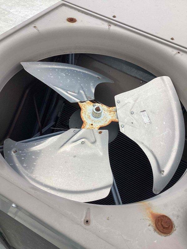 Replaced failed condenser fan motors, blades, and capacitors on commercial HVAC unit. Removed corroded fan assembly showing significant rust on mounting hardware and hub, installed new motor assemblies with factory-spec blades, and verified proper rotation and airflow upon startup.