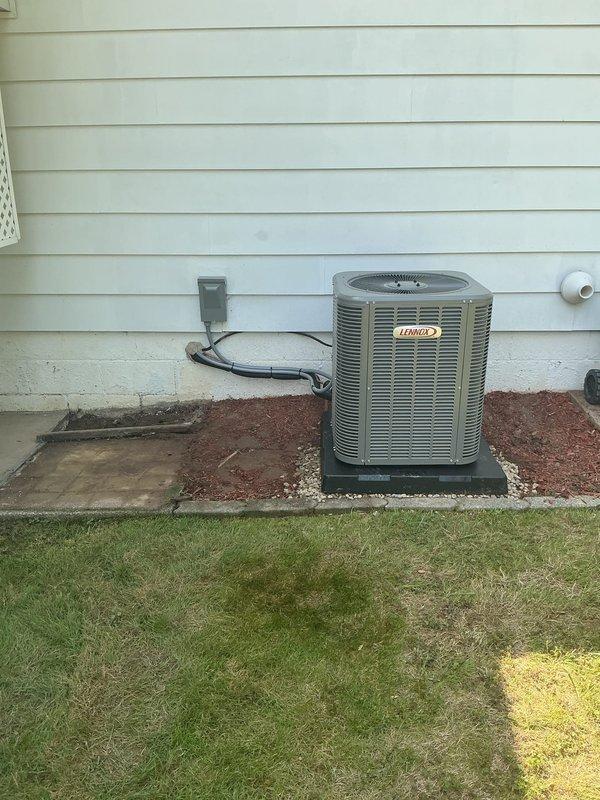 # HVAC Install - Complete System

Completed full furnace and air conditioning system retrofit at residential property. Installed new Lennox outdoor condensing unit on level pad with proper clearances from structure. Unit positioned on black equipment pad with stone base for drainage and stability. Ran new electrical conduit and wiring from unit to exterior disconnect switch mounted on house siding. Verified proper electrical connections and secure mounting of all exterior components.

Interior furnace installation completed with new equipment tied into existing ductwork system. All refrigerant lines properly insulated and secured. System startup performed with verification of proper airflow, refrigerant charge, and electrical operation. Unit tested through complete heating and cooling cycles to confirm proper operation. All safety controls and disconnect switches verified functional. Installation meets manufacturer specifications and local code requirements.