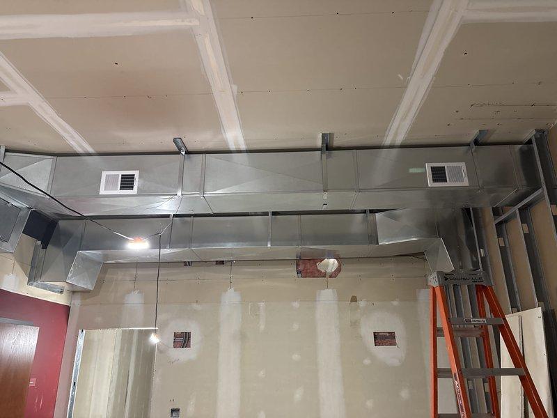 Completed commercial HVAC installation including offset installation after duct elbow and ductwork rework in new construction space. Installed stainless steel rectangular ductwork with integrated white air diffusers in coffered ceiling system, connected flexible duct runs to air handler unit in attic space, and performed preventive maintenance inspection. All ductwork properly secured with mounting brackets and sealed connections verified for optimal airflow performance.