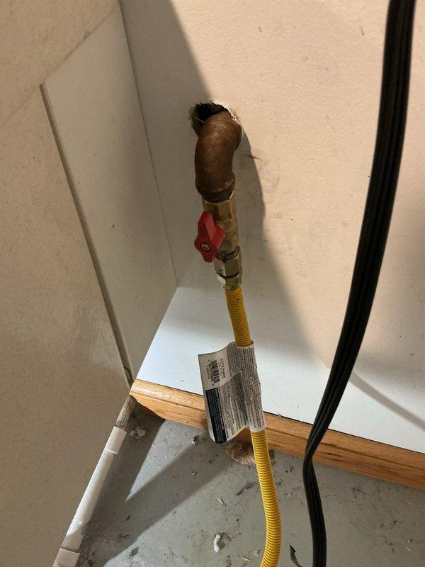 Responded to service call regarding two plumbing concerns: a toilet with intermittent refilling issues and a gas line shut-off valve requiring modification. Inspected toilet tank and identified discolored water with visible sediment and mineral deposits throughout the tank interior, along with aging flush valve assembly and fill valve components showing corrosion. Examined flexible CSST gas connector with brass shut-off valve installed for dryer connection. Customer requested valve extension to improve accessibility for complete shut-off operation. Documented existing conditions of both toilet mechanism and gas line installation with photographs for service records.