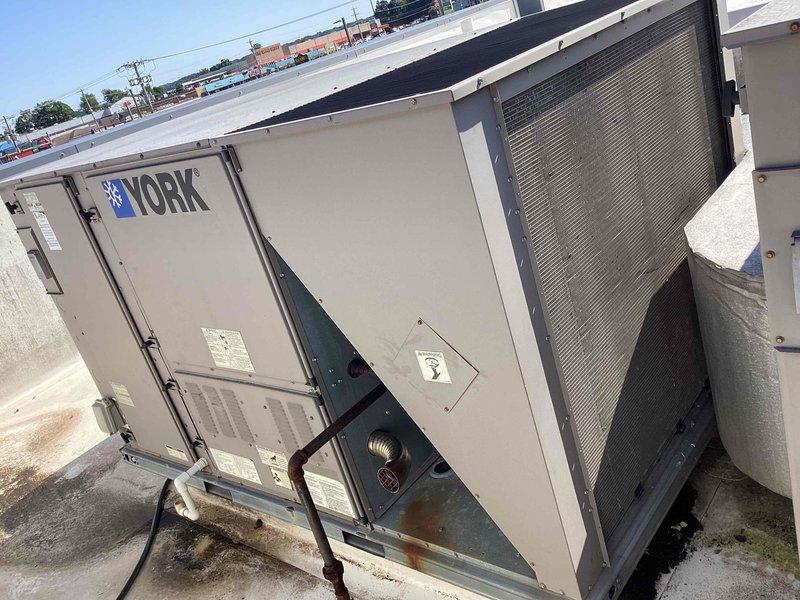 Completed scheduled commercial cooling maintenance on York rooftop package unit. Performed comprehensive inspection of exterior cabinet, condenser coil section, and internal components including refrigerant lines, electrical connections, and insulated suction lines. Verified all access panels secure, examined copper refrigerant piping and brass fittings for proper connections, and confirmed system operational status with no significant issues identified during routine service visit.