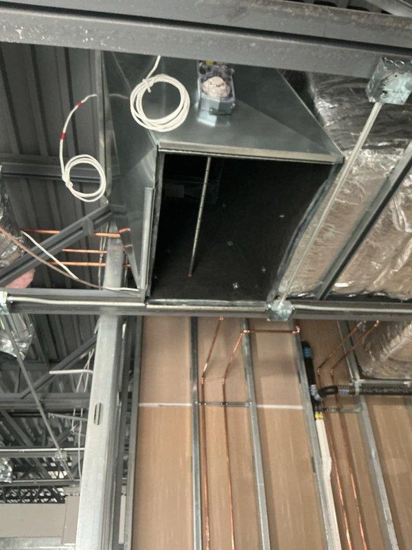 Completed commercial HVAC new construction installation including hanging range hood with roof venting, running control wiring, finishing spiral ductwork, installing economizer pop-out, and mounting power exhaust unit. All ductwork, refrigerant lines, and mechanical equipment were properly secured and positioned per specifications, with control systems wired and tested for proper operation.