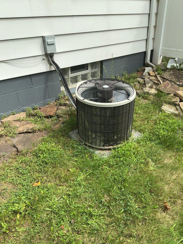Completed comprehensive HVAC system replacement estimate for residential property requiring furnace and air conditioning retrofit. Assessed existing basement-mounted furnace installation with exposed blower assembly and evaluated current ductwork configuration including galvanized sheet metal distribution system. Inspected outdoor condensing unit positioned on concrete pad adjacent to home foundation, noting electrical disconnect and refrigerant line routing. Documented system specifications and photographed equipment layout to provide detailed replacement proposal for complete heating and cooling system upgrade.
