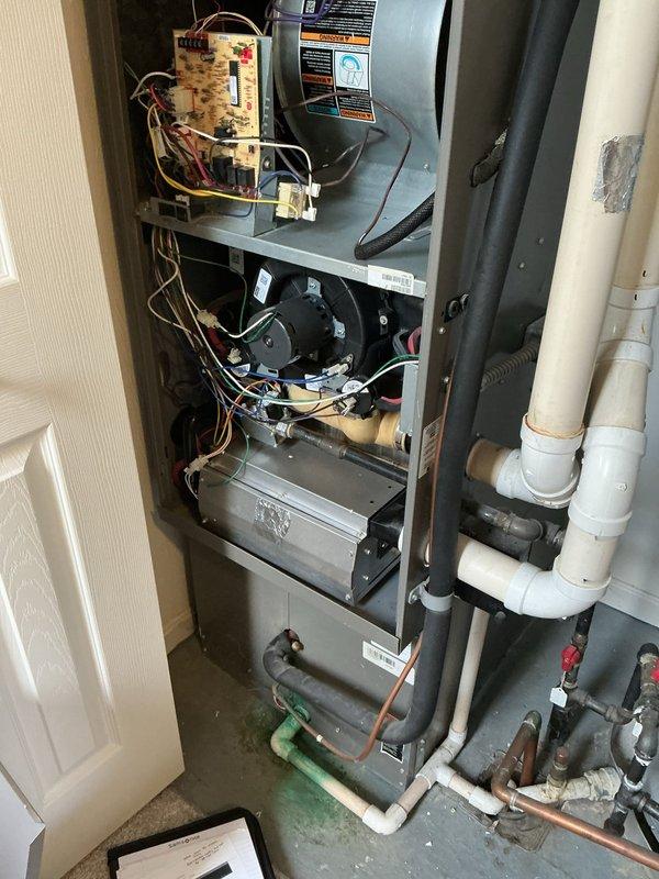 Completed A/C retrofit installation in utility closet, replacing existing HVAC system with new vertical cabinet unit featuring integrated humidification system. Installed drum-style humidifier assembly, configured control board wiring and electrical connections, and established PVC drainage piping with valve controls to ensure proper condensate management and water supply for humidification functionality.