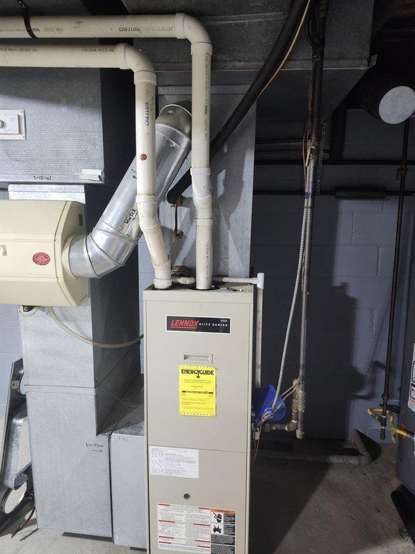 Completed full residential air conditioning system replacement. Installed new Lennox outdoor condenser unit on existing concrete pad adjacent to building foundation, connected to electrical disconnect box via conduit. Unit properly positioned and leveled with all refrigerant lines, electrical connections, and condensate drainage completed to manufacturer specifications. Indoor air handler integrated with existing furnace system, with all ductwork transitions and PVC drain lines secured and tested for proper operation. System startup performed, refrigerant charge verified, and all safety controls confirmed functional.