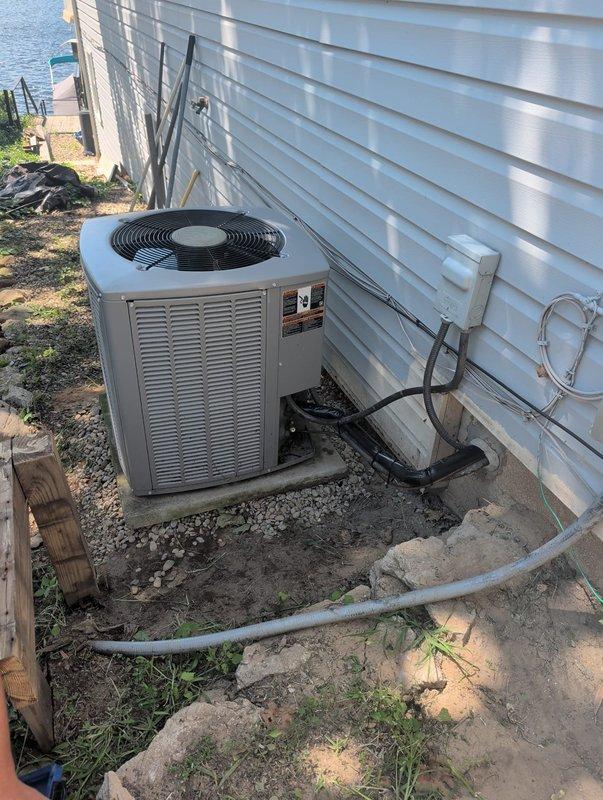 Completed new construction HVAC installation of residential air conditioning system. Installed outdoor condenser unit on gravel pad adjacent to house exterior with proper clearances, ran refrigerant lines and electrical conduit up exterior wall with secure mounting brackets, installed electrical disconnect box, and routed PVC condensate drain line. Charged system with R-410A refrigerant, performed manifold gauge diagnostics to verify proper pressures and system operation, and confirmed unit is functioning correctly with all components operational.