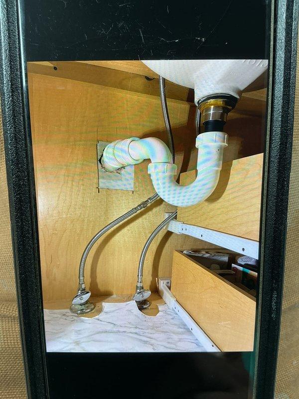 Provided estimate for installation of two-handle chrome Emerson faucet assembly on existing bathroom sink. Replacement of existing 4-20 inch flexible braided supply lines required to accommodate new fixture specifications. Documented current under-sink plumbing configuration including P-trap assembly and existing supply line connections for accurate material sizing and installation planning.
