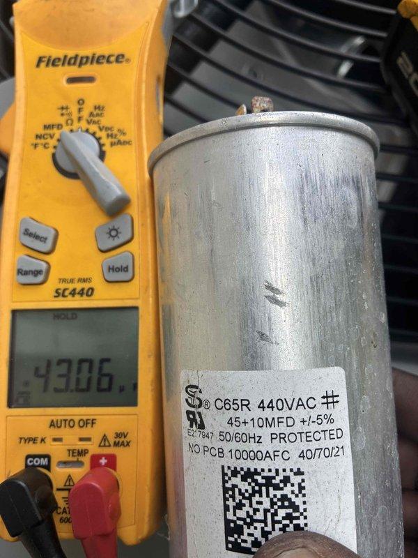 Completed routine commercial cooling maintenance on outdoor condensing unit. Performed diagnostic testing of dual-run capacitor using digital multimeter, confirming proper microfarad readings on 45+10 MFD capacitor rated at 440VAC. All electrical components tested within manufacturer specifications. Unit operating normally with no deficiencies noted.