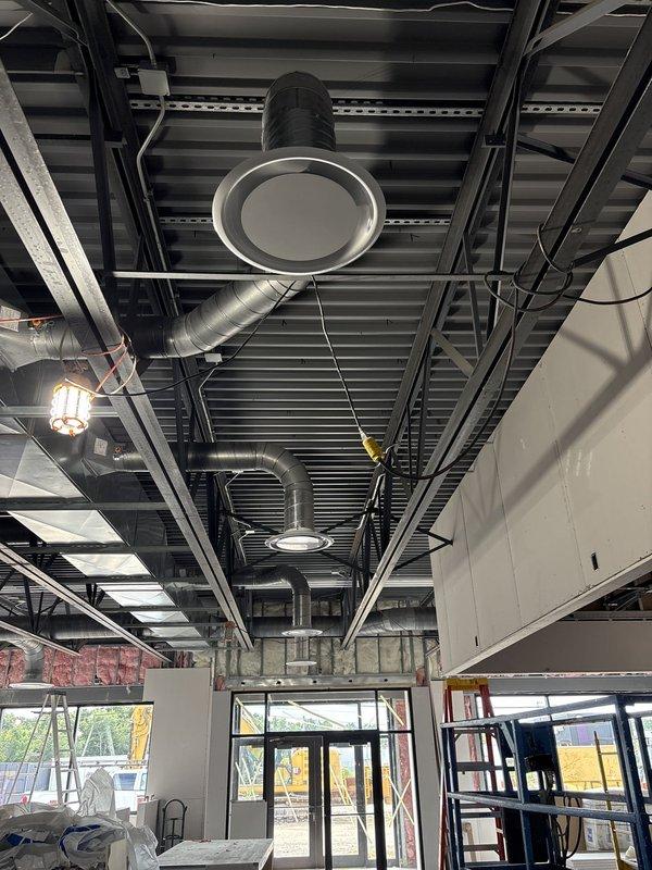 Completed installation of spiral ductwork and circular ceiling diffusers in commercial space with exposed ceiling design. Mounted power exhaust system and integrated all HVAC components with existing structural framework, ensuring proper airflow distribution throughout the facility.