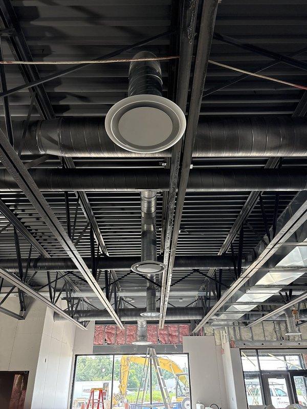 Completed installation of spiral ductwork and circular ceiling diffusers in commercial space with exposed ceiling design. Mounted power exhaust system and integrated all HVAC components with existing structural framework, ensuring proper airflow distribution throughout the facility.