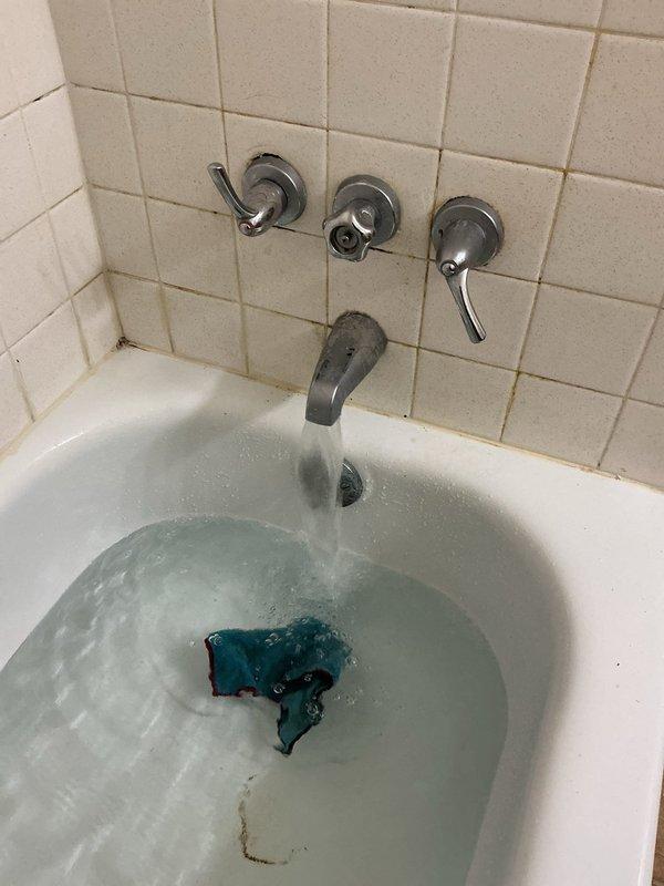 Responded to a shower leak located behind the washer and dryer access panel. Upon inspection, identified deteriorating plumbing connections with visible corrosion and rust staining on piping and surrounding metal panels. Accessed the affected area by moving appliances, repaired the leaking shower valve assembly, and addressed compromised pipe insulation showing significant wear and cracking. Tested the system to confirm proper operation and leak elimination.
