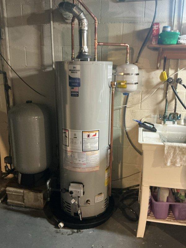 Installed a 40-gallon Bradford White tall water heater in the basement utility area, including all necessary copper piping connections and proper venting configuration. A pressure gauge was mounted on brass valve fittings to monitor system pressure, completing the installation to ensure safe and efficient operation of the new water heating system.