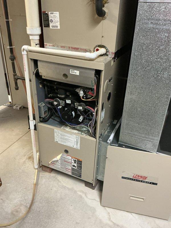 Completed full HVAC system replacement including installation of new Lennox furnace and matching outdoor condensing unit. Removed existing equipment and installed new high-efficiency furnace in basement utility area with proper venting using white PVC piping for intake and exhaust. Positioned new Lennox condensing unit on existing concrete pad against exterior wall, connected refrigerant lines, and established electrical connections. Verified all components are operational, tested system performance, and ensured proper airflow through ductwork connections.