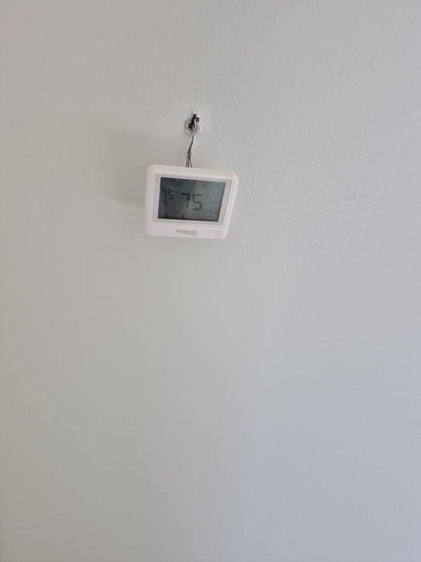 Completed installation of HVAC registers and hood vent system in new construction property. Finalized furnace condensate drain line connections and verified proper drainage. Installed thermostat wiring and mounted digital control unit on interior wall for system operation.