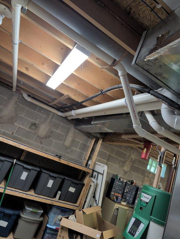 Completed furnace retrofit installation in residential basement utility area. Installed new furnace system with PVC venting and condensate drainage routed through exterior wall, terminating at foundation level with proper pitch and support. Integrated new equipment with existing ductwork system, electrical service panel, and plumbing infrastructure in basement mechanical room. All exhaust and intake venting installed per manufacturer specifications using appropriate PVC materials, penetrating brick exterior wall and secured with proper clearances from grade and building materials. System tested and operational upon completion.