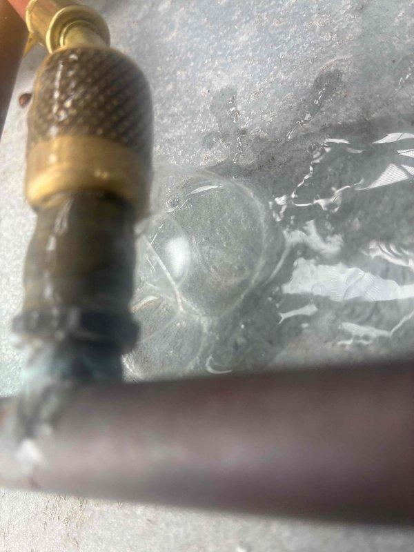 Responded to no cooling complaint on commercial HVAC unit. Performed comprehensive refrigerant leak search on system. Inspected compressor, refrigerant lines, and valve connections using close visual examination. Identified potential leak point at service valve with mesh filter body connected to refrigerant circuit. Documented findings with detailed photographs of suspect valve assembly and overall system condition for further evaluation and repair recommendations.