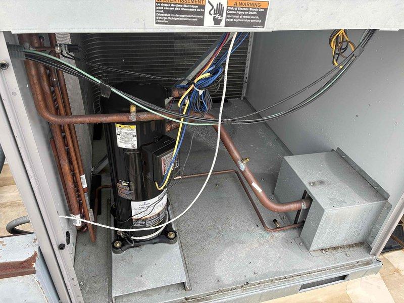 Responded to no cooling complaint on commercial HVAC unit. Performed comprehensive refrigerant leak search on system. Inspected compressor, refrigerant lines, and valve connections using close visual examination. Identified potential leak point at service valve with mesh filter body connected to refrigerant circuit. Documented findings with detailed photographs of suspect valve assembly and overall system condition for further evaluation and repair recommendations.