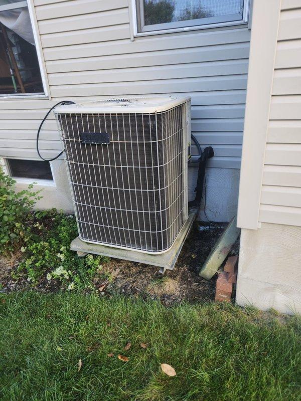 Completed full HVAC system retrofit including furnace and air conditioning equipment. Installed new furnace unit in basement mechanical room with proper clearances and venting, positioned between existing concrete block walls in confined utility space. Installed new outdoor condenser unit on concrete pad against exterior wall with appropriate refrigerant line connections and electrical conduit routing to house. All equipment installed per manufacturer specifications and local code requirements, system tested and operational.