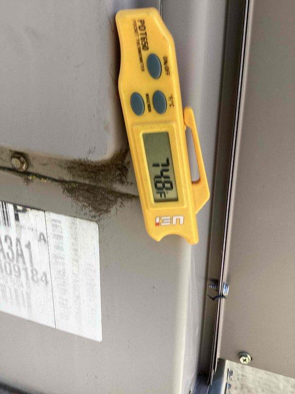 Replaced failed condenser fan motor, fan blade, and run capacitor on commercial air conditioning unit. Verified proper operation with temperature readings and confirmed new fan assembly spinning freely with adequate airflow through protective grille.