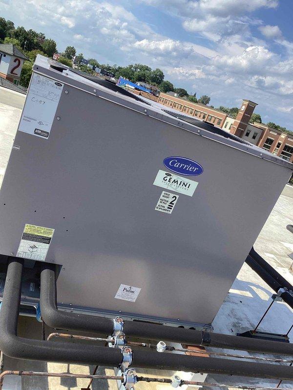Completed scheduled commercial cooling maintenance on rooftop Carrier GEMINI unit #2. Performed routine inspection of RTU components, verified operational status of compressor and condenser sections, and checked refrigerant lines and valve connections. Inspected rooftop exhaust ventilation system including dual-cylinder aluminum stack assembly with dome cap and mesh screening. All equipment found operating within normal parameters with no immediate service needs identified.
