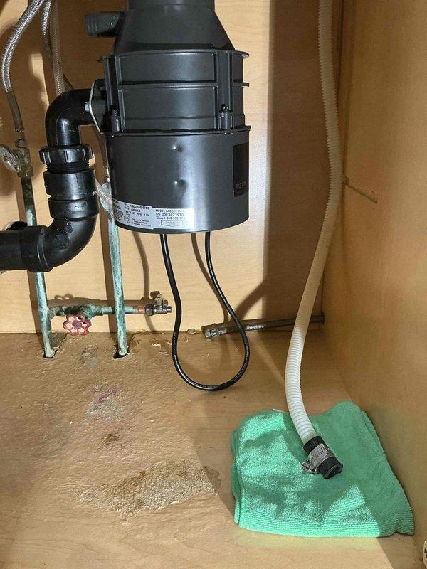 Installed new garbage disposal unit under kitchen sink and inspected dishwasher supply line for proper function and integrity. Verified all plumbing connections were secure and tested disposal operation to ensure proper drainage and functionality.