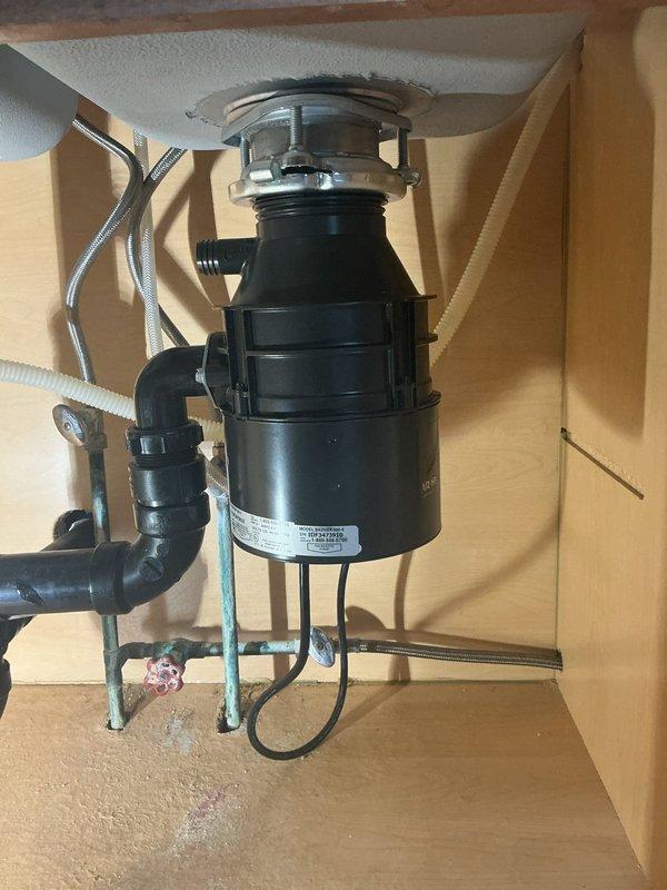 Installed new garbage disposal unit under kitchen sink and inspected dishwasher supply line for proper function and integrity. Verified all plumbing connections were secure and tested disposal operation to ensure proper drainage and functionality.