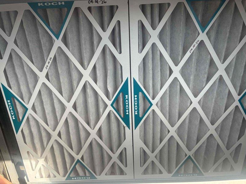 Completed spring maintenance on commercial HVAC unit. Replaced three Koch brand pleated air filters with new units, documenting installation with date notation. Verified proper filter installation in access compartment and confirmed secure seating within metal track system.