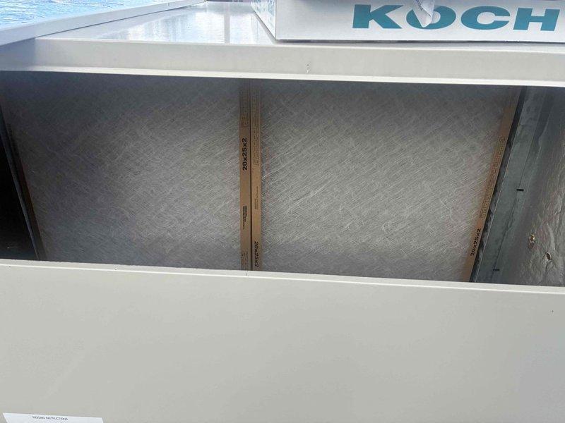 Completed spring maintenance on commercial HVAC unit. Replaced three Koch brand pleated air filters with new units, documenting installation with date notation. Verified proper filter installation in access compartment and confirmed secure seating within metal track system.
