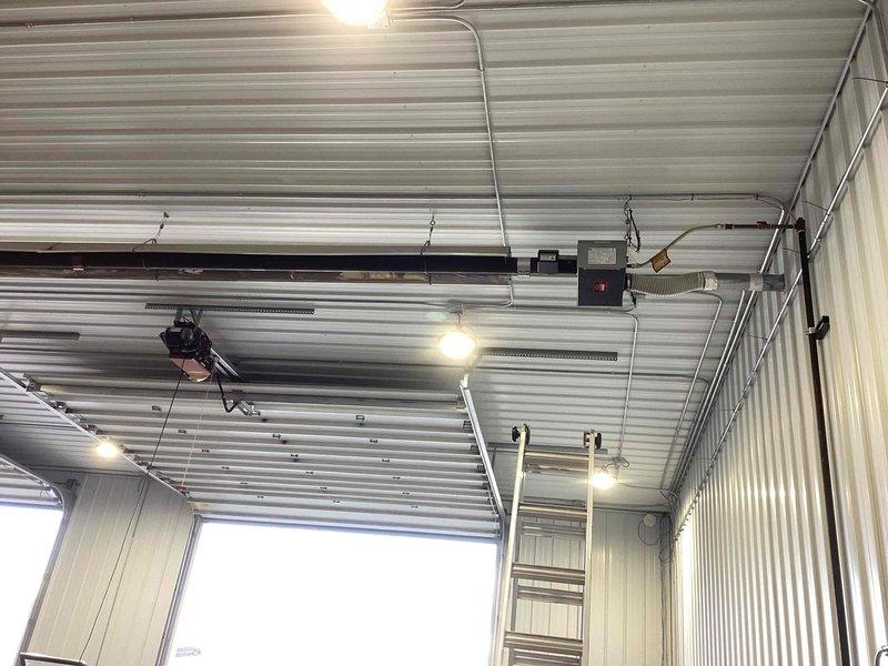 Responded to service call for commercial tube heater that experienced operational issues at end of previous heating season. Performed diagnostic inspection of unit mounted in overhead warehouse space behind retail establishment. Utilized infrared thermometer to assess temperature readings and evaluate system performance, documenting current conditions with thermal measurements showing subzero readings indicating potential heating element or combustion issues. Inspected flexible ductwork connections, mounting hardware, and overall unit installation in corrugated metal ceiling structure to identify cause of malfunction and determine necessary repairs.