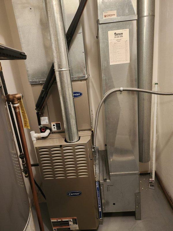Completed A/C retrofit installation including new outdoor condensing unit and indoor evaporator coil matched to existing Carrier furnace system. Removed and properly disposed of old weathered outdoor unit that showed significant rust and corrosion on housing and base components. Installed new condensing unit on existing concrete pad, established refrigerant line connections using copper piping, and ran new electrical disconnect with conduit to exterior wall mount. Indoor evaporator coil was installed above furnace in existing ductwork plenum with proper refrigerant line routing through utility space. Verified all electrical connections at disconnect box, completed refrigerant charging to manufacturer specifications, and tested system operation for proper cooling cycle. System achieved target temperatures with appropriate airflow through ductwork. All connections secured and leak-tested per industry standards.