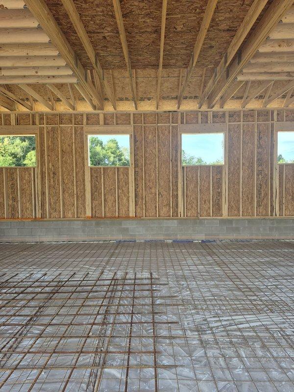 Completed HVAC rough-in installation for Reznor unit at new construction site during pre-concrete pour phase. Coordinated equipment placement and utility routing through framed structure with exposed floor joists and rebar grid in preparation for slab installation. Performed project management walkthrough and documented installation progress with site photography.