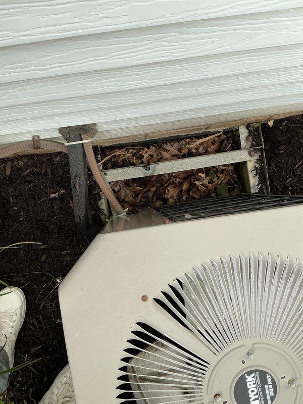 Conducted comprehensive assessment of existing HVAC system and provided detailed estimate for complete system replacement. Presented pricing options including base system installation and available upgrades: Aprilaire 600M humidifier for enhanced indoor humidity control, upgraded air cleaner for improved filtration, and Ecobee smart thermostat (base package includes Honeywell S200 thermostat). Documented current outdoor condensing unit condition, noting unit positioned against building exterior with surrounding vegetation requiring clearance consideration for optimal airflow and future service access. Photographed existing equipment installation including condenser unit placement, electrical disconnect location, and refrigerant line routing along exterior wall.