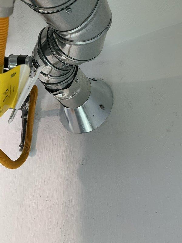 Completed installation of Reznor heater unit with Quick Sling mounting system in new construction space. Shortened B-vent pipe protrusion from ceiling to proper specifications and secured all ductwork connections with metal clamps. Installed thermostat and associated electrical conduit, ensuring all ventilation components are properly mounted and functional.