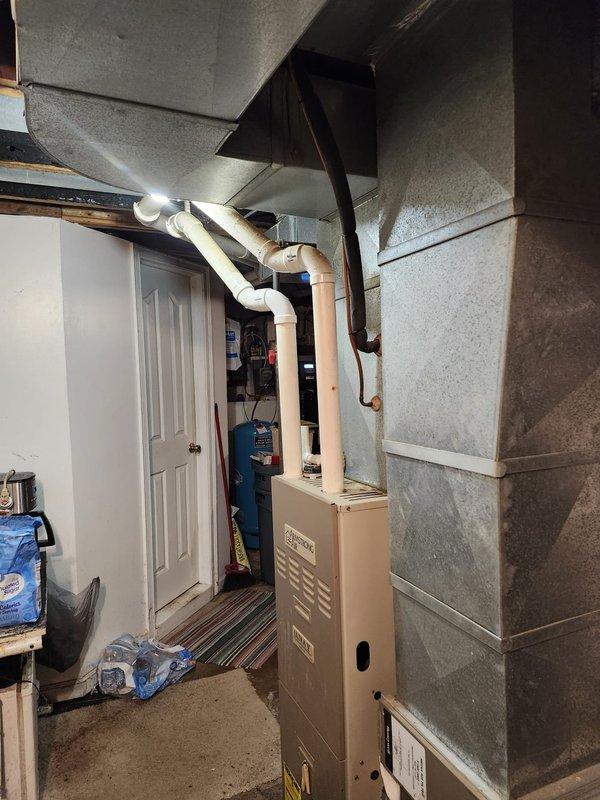 Completed full HVAC system installation in basement utility area, including new furnace unit with integrated ductwork and ventilation components. Installed and connected white PVC condensate drainage piping and copper refrigerant lines with proper fittings and support. Configured metallic supply ductwork to ceiling joists with appropriate hangers and sealed all connections to ensure efficient airflow distribution throughout the residence.