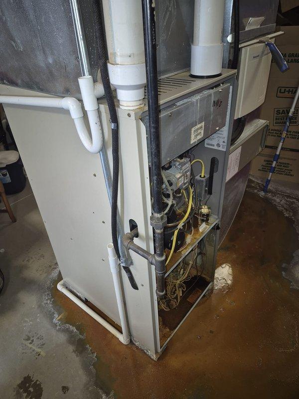 Performed inspection of HVAC system coil drain pan per service request. Upon examination, confirmed visible cracking in drain pan with evidence of water damage and staining on concrete floor beneath unit. Documented condition with photographs showing moisture-related discoloration around base of air handler. Recommended drain pan replacement to prevent future water damage and potential system issues.