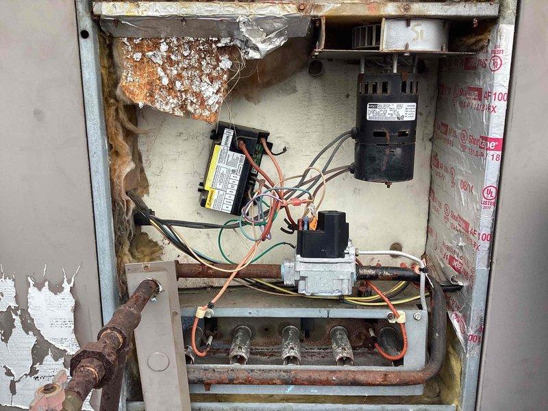 Completed scheduled commercial heating maintenance visit on rooftop unit. Performed comprehensive system inspection revealing significant cabinet deterioration with peeling paint and corrosion on burner assembly and interior surfaces. Conducted operational testing using dual-port manometer to verify gas pressures and system performance, recording readings of 0.04" and 3.59" w.c. Inspected all major components including blower motor, ignition control board, gas valve, and burner manifold. Documented advanced age and weathering of equipment with photographic evidence showing oxidation on metal components and rust formation on burner assembly. System currently operational but exhibiting signs of age-related deterioration that will require monitoring during future service visits.