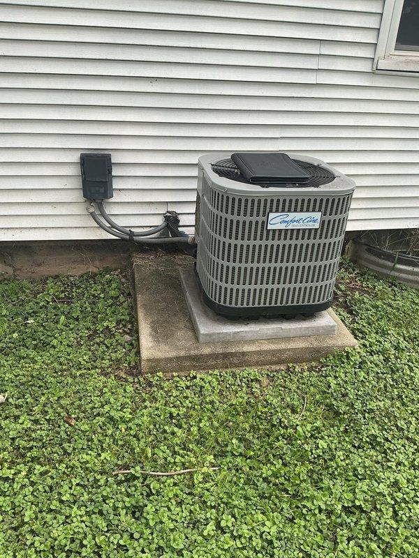 Completed full HVAC system replacement estimate for residential property. Assessed existing outdoor condensing unit with cylindrical vertical fin design connected to house via conduit and disconnect box, noting standard installation on concrete pad. Evaluated indoor basement equipment including condensate pump system and ductwork, documenting significant moisture issues with standing water on concrete floor that will require attention during installation planning.