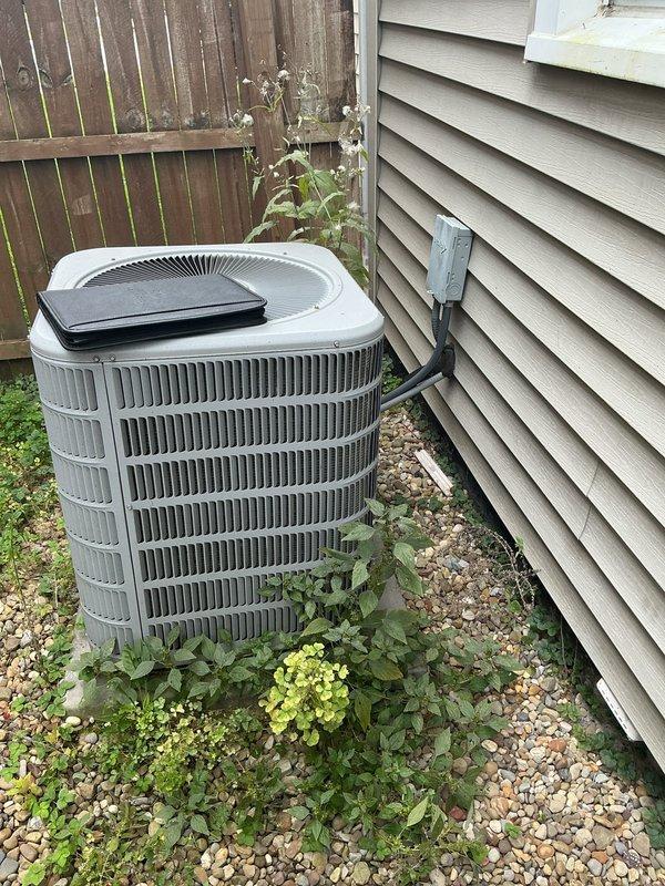 Completed full HVAC system retrofit installation including replacement of gas furnace and air conditioning condenser unit. Installed new gray cabinet-style furnace in basement utility area with proper venting using white PVC ductwork routed along ceiling joists. Positioned outdoor AC condenser unit on gravel pad against exterior wall with appropriate clearances and connected refrigerant lines via conduit along vinyl siding. Verified all electrical connections, tested system operation, and confirmed proper condensate drainage with collection pan installation at furnace base.