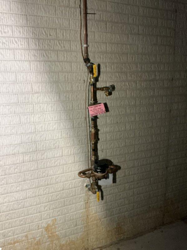 Responded to water leak complaint with water present on basement floor and doubled water bill. Conducted thorough inspection of plumbing system including water heater, main supply lines, and fixture connections. Inspected basement piping assembly showing age-related corrosion and rust on metal pipes and fittings. Examined kitchen sink plumbing including garbage disposal unit and PVC drainage connections for potential leak sources. Traced water supply lines and shut-off valves throughout affected areas. Identified leak source and completed necessary repairs to stop active water loss. Verified all connections were secure and tested system operation to ensure proper function. Documented conditions with photographs for service records.